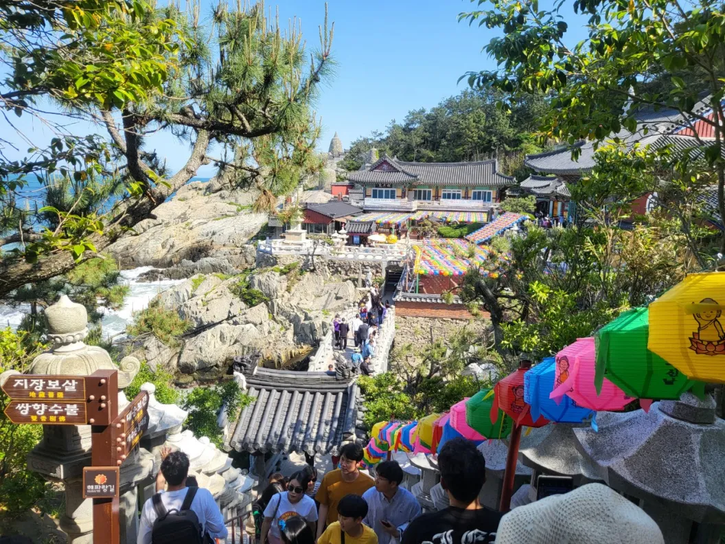 A seaside temple with lanterns on the rocks